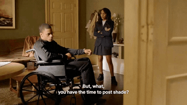 a man in a wheelchair talks to a woman in a suit