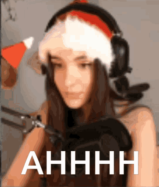 a woman wearing headphones and a santa hat says " ahhhh " in white letters