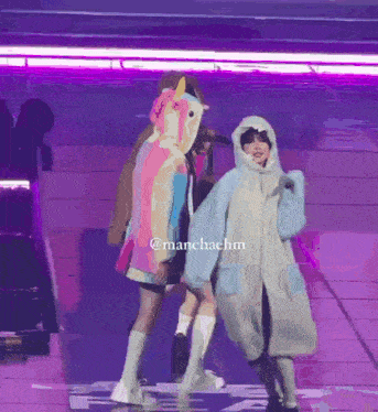 a person in a unicorn costume is standing next to another person