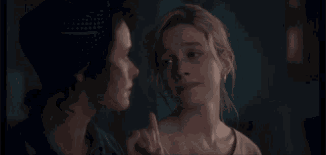 two women are standing next to each other and one is pointing at the other
