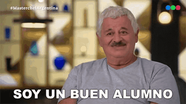 a man with gray hair and a mustache is smiling and says soy un buen alumno