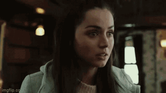 a close up of a woman 's face in a room in a movie .