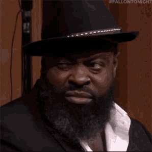 a man with a beard wearing a top hat and suit .