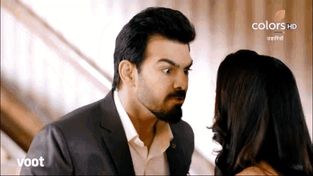a man and a woman are looking at each other on a screen that says colors hd on it