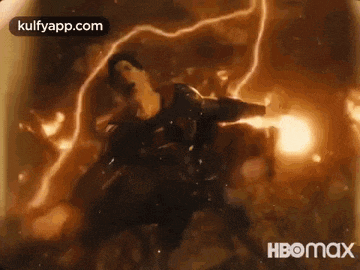 a man is standing in the middle of a fire while another man is standing in the background .
