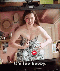 a woman is talking on a video call and the words it 's too booby are on the screen behind her