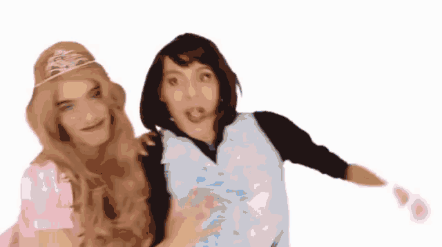 a man and a woman are posing for a picture together . the woman is wearing a tiara .