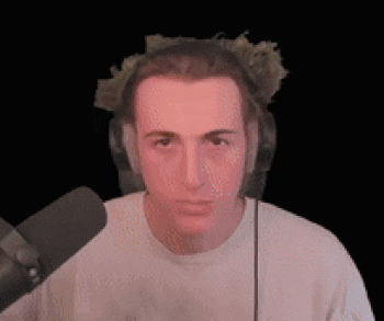 a young man wearing headphones and a white shirt is looking at the camera .