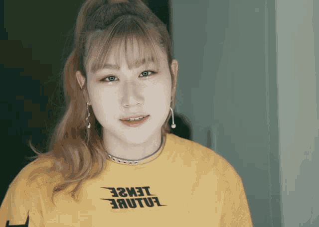 a girl wearing a yellow shirt that says " ealue "