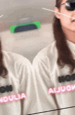 a woman wearing sunglasses and a white shirt that says aljugua on it