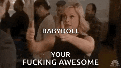 a woman is giving a thumbs up in front of a crowd of people and says `` babydoll your fucking awesome '' .