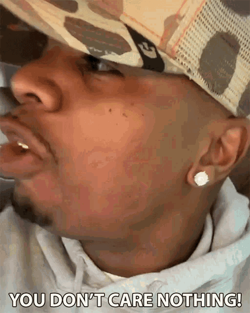 a man wearing a hat and earrings says you don t care nothing
