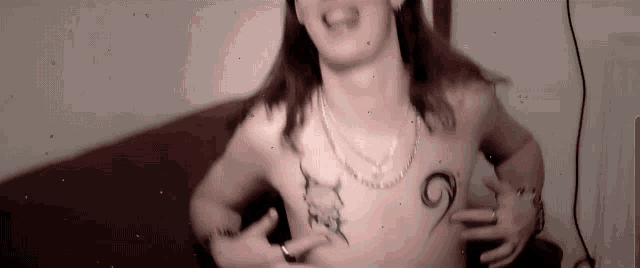 a shirtless man with tattoos on his chest