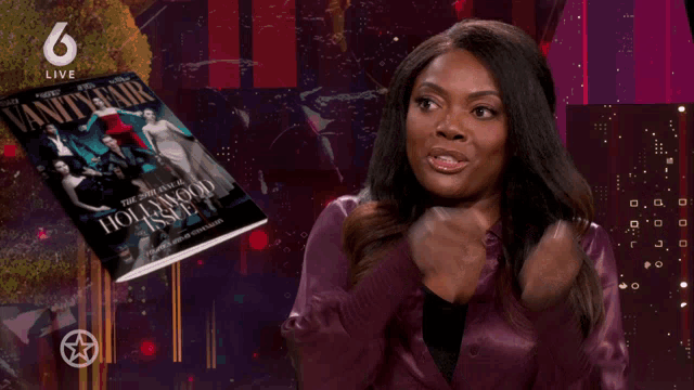 a woman sits in front of a vanity fair hollywood issue