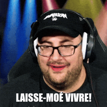 a man wearing headphones and a hat says laisse-moe vive