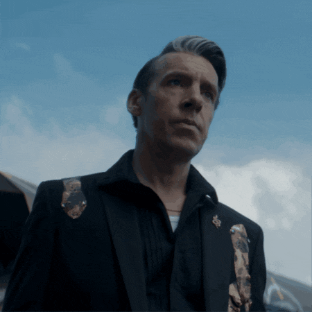 a man wearing a black suit and a black shirt