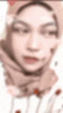 a blurred image of a woman wearing a hijab