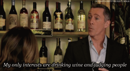 a man talking to a woman with the words my only interests are drinking wine and judging people behind him