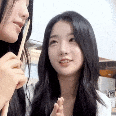two young women are standing next to each other in a kitchen .