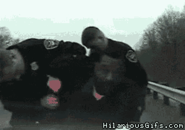 a couple of police officers standing next to each other with hilariousgifs.com written in the corner
