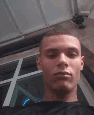 a young man taking a selfie in front of a glass door