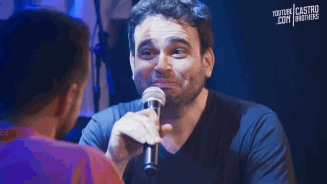 a man singing into a microphone with youtube castro brothers written on the bottom right