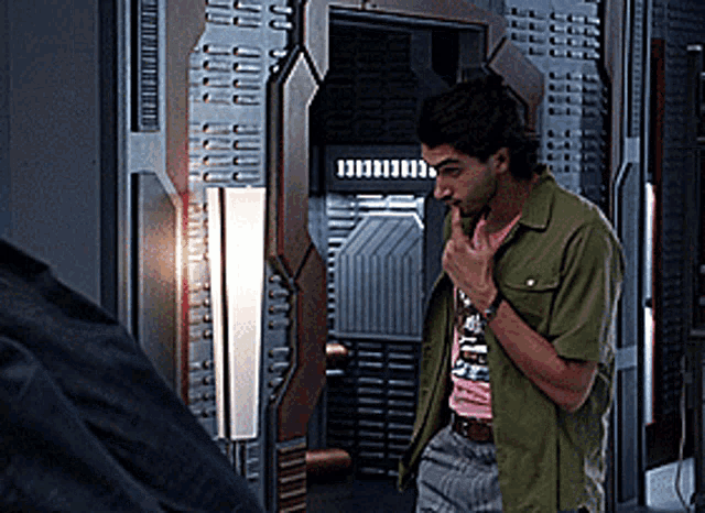 a man in a green shirt is standing in front of a door that says ' i 'm sorry ' on it