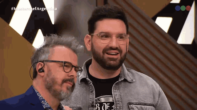 a man with glasses and a beard is standing next to another man with a beard