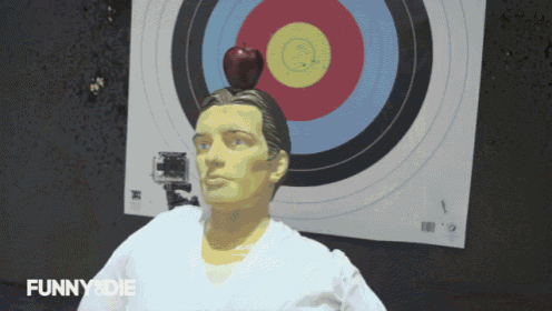 a man with an apple on his head is standing in front of a target that says funny & die
