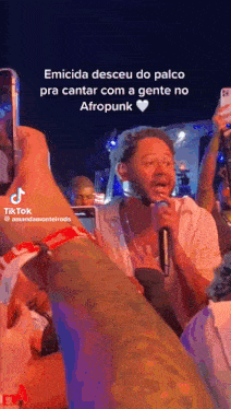 a man singing into a microphone with the words emicida desceu do palco on the bottom