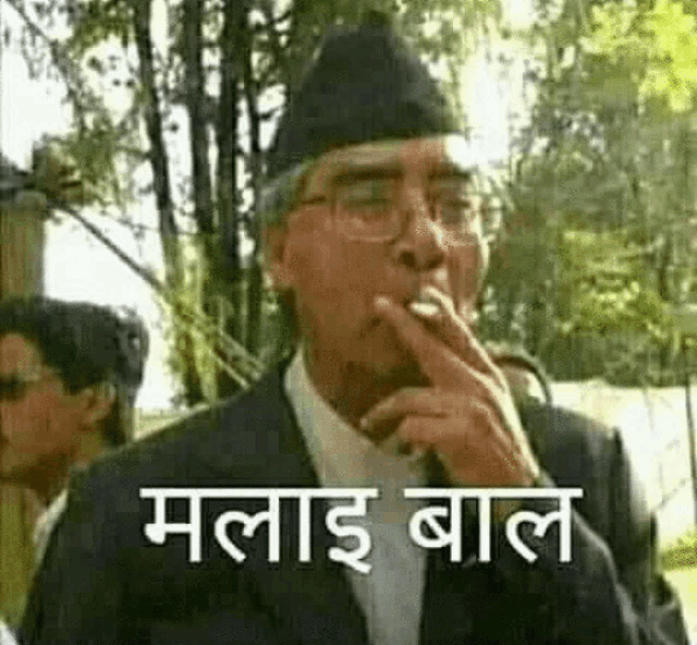 a man in a suit and hat is smoking a cigarette with a caption in a foreign language .