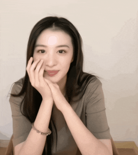 a woman with her hand on her face is wearing a bracelet on her wrist