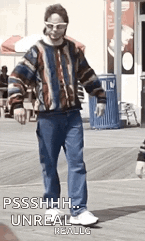 a man in a striped sweater and jeans is dancing on a beach .