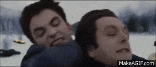 a couple of men are standing next to each other and one of them is laying on the ground .