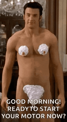 a naked man with whipped cream on his chest and breasts is standing in a room .