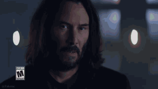 a man with long hair and a beard is looking at the camera with a warning sticker on his face that says mature content