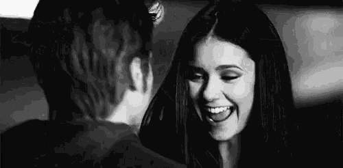 a man and a woman are looking at each other and smiling .