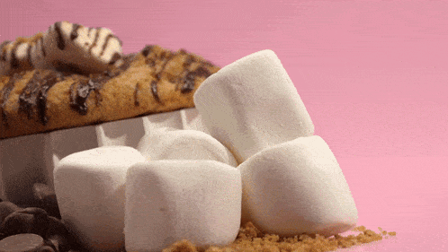 a pile of marshmallows sitting next to a s'mores cookie