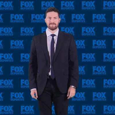 a man in a suit and tie is dancing in front of a fox deportes wall