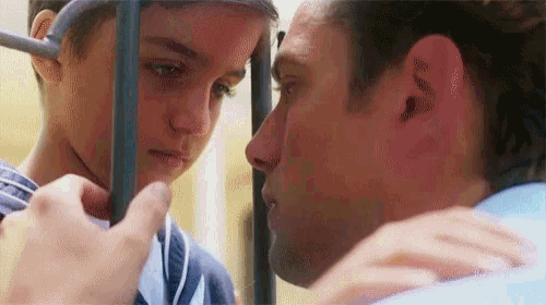 a man and a boy look at each other through bars