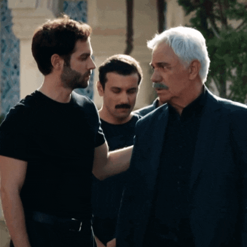 a man with a mustache is standing next to two other men