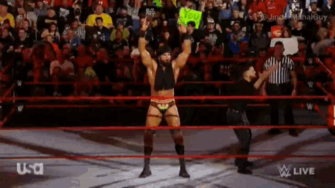 a man in a wrestling ring holds a sign that says i love you
