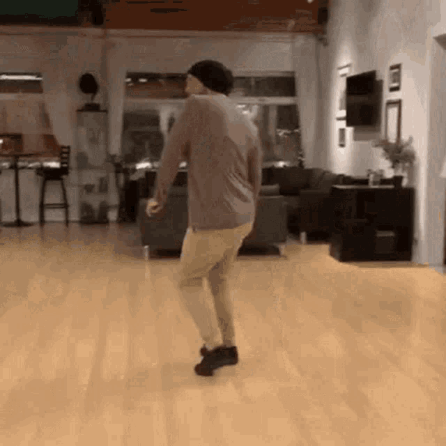 a man is dancing on a wooden floor in a room .