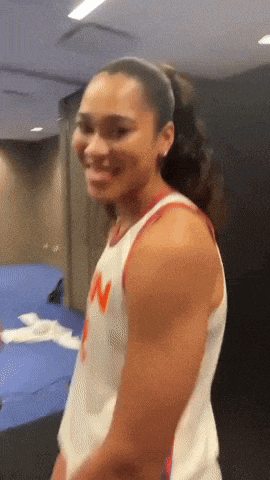 a woman wearing a jersey with the letter w on it smiles