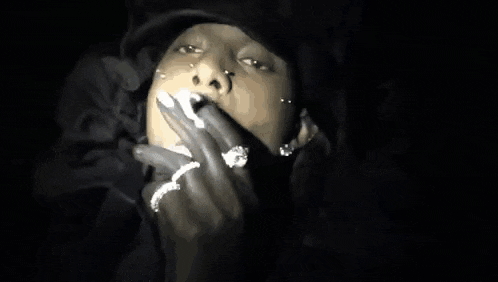 a woman is smoking a cigarette in the dark .