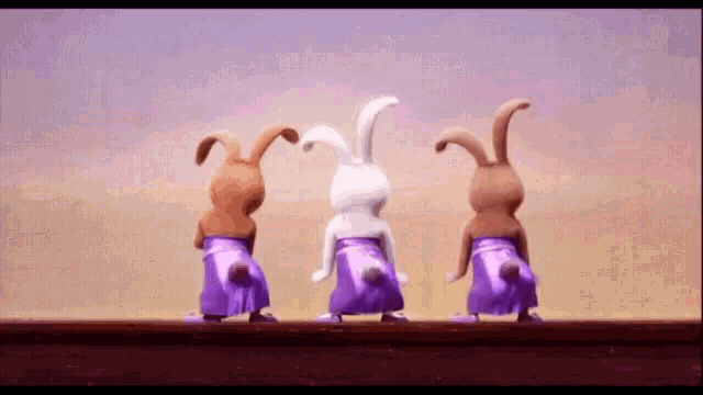 three rabbits are standing next to each other with their backs facing the camera