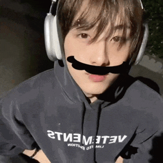 a man wearing headphones and a hoodie that says 2t3m3t3v on it