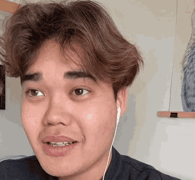 a man wearing ear buds is smiling and looking at the camera