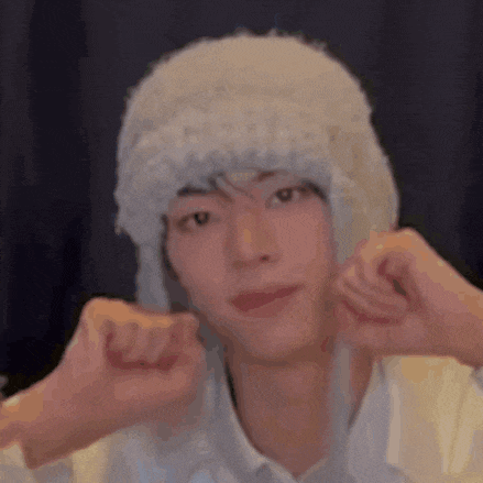 a young man wearing a white hat is making a face .