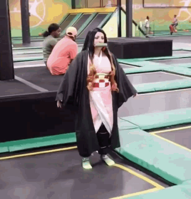 a woman is standing on a trampoline wearing a kimono .